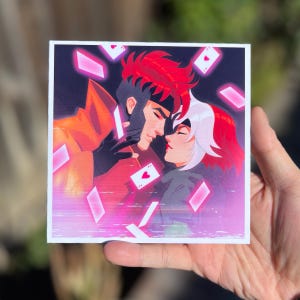 May include: A digital art print of two characters from a comic book, a man with red hair and a woman with white hair, looking at each other with a romantic expression. The background is a dark blue with pink and red playing cards falling from the sky.