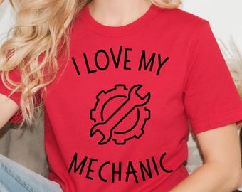 Puede incluir: Camiseta roja con texto negro que dice "Me encanta mi mecánico" y un gráfico negro de una llave y un engranaje.