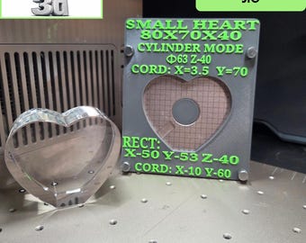 Könnte beinhalten: Ein herzförmiges Objekt aus klarem Acryl neben einer grauen, rechteckigen physischen Vorrichtung. Die Vorrichtung zeigt grünen Text, darunter SMALL HEART 80X70X40, CYLINDER MODE, 63 Z-40, CORD: X=3.5 Y=70, RECT: X-50 Y-53 Z-40 und CORD: X-10 Y-60.