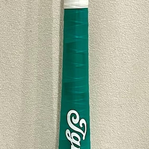 May include: A teal baseball bat with white accents and the name "Ignacio" in white script. The word "BOSTON" is printed in white block letters near the base of the bat.