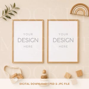 Könnte beinhalten: Zwei vertikale Rahmen aus hellem Holz mit weißen Einlagen und dem Text YOUR DESIGN HERE. Die Szene enthält einen kleinen Regenbogen aus Holz, eine Spielzeugkamera, einen Stapelturm aus Holz und zwei Holzklötze sowie einen grünen Blattzweig.
