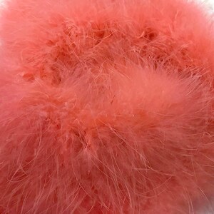 May include: A close-up of a bunch of soft, pink feathers. The feathers are fluffy and delicate, and they are perfect for crafting or decorating.