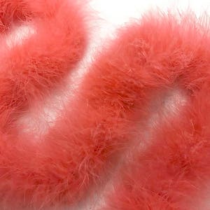 May include: A close-up of a bundle of pink feather boas. The boas are soft and fluffy, and they are perfect for adding a touch of glamour to any outfit.