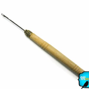 Puede incluir: Un enhebrador de aguja de madera con una punta de metal y una perilla de latón decorativa. El enhebrador de aguja mide aproximadamente 15 cm de largo.