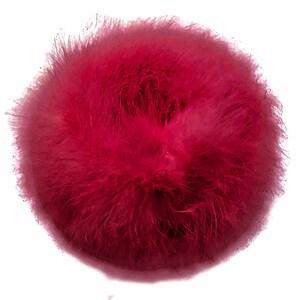 Puede incluir: Un pomp&oacute;n esponjoso de color rojo oscuro. El pomp&oacute;n est&aacute; hecho de un material suave y peludo y es perfecto para agregar un toque de fantas&iacute;a a cualquier proyecto.