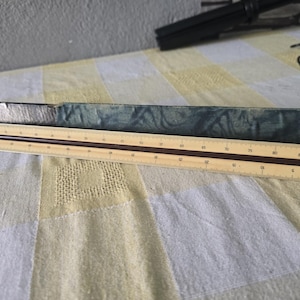 May include: A wooden architectural scale ruler with brown markings and a dark blue case. The ruler is approximately 12 inches long. The scale is on a yellow and brown background.