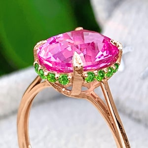 Anillo de zafiro rosa en oro de 14 quilates con halo de tsavoritas y zafiro ovalado. Joyería con estilo inspirado en la naturaleza.