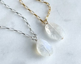 May include: Two delicate necklaces with moonstone pendants. One necklace has a gold chain and the other has a silver chain.