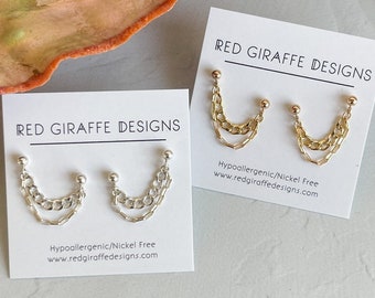 May include: Two pairs of gold and silver chain earrings on white cards with the text "RED GIRAFFE DESIGNS" and "Hypoallergenic/Nickel Free www.redgiraffedesigns.com".