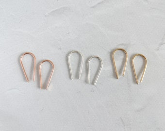 May include: Three pairs of small, teardrop-shaped earrings in gold, silver, and rose gold.
