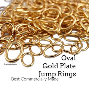 May include: A large pile of shiny gold-plated oval jump rings. The text on the image reads: Creating Unkamen, Oval Gold Plate Jump Rings, Best Commercially Made. These metal jewelry findings feature a smooth, reflective finish and an open oval shape.