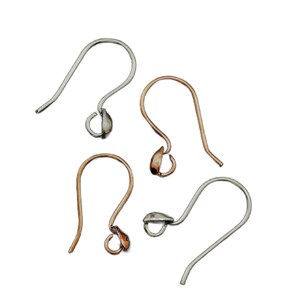May include: Four silver and gold earring hooks with a teardrop-shaped loop at the end. The hooks are arranged in a scattered pattern on a white background.