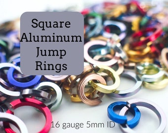 May include: A close-up of a pile of colorful square aluminum jump rings. The rings are 16 gauge and have a 5mm inner diameter.  Square Aluminum Jump Rings.
