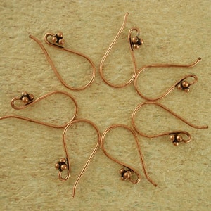 May include: Six copper earring hooks with a cluster of three small balls at the end of each hook.