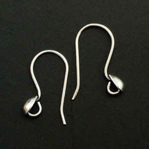 May include: Two silver earring hooks with a small round ball at the end of each hook.