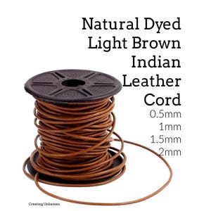 May include: A spool of natural dyed light brown Indian leather cord. The black plastic spool is wrapped with the cord, and the text reads: Natural Dyed Light Brown Indian Leather Cord 0.5mm 1mm 1.5mm 2mm. The cord is thin and flexible.