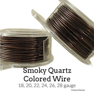 May include: Two spools of smoky quartz colored wire in clear plastic containers. The wire gauges are 18, 20, 22, 24, 26, and 28. The text "Smoky Quartz Colored Wire" is printed below the spools.