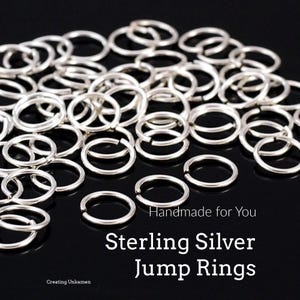 May include: A collection of numerous small, circular sterling silver jump rings with an open seam. The text "Handmade for You", "Sterling Silver Jump Rings", and "Creating Unkamen" is printed in white on the dark surface among the metal rings.