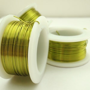 May include: Three spools of green wire, each wound around a white plastic spool. The wire is shiny and has a metallic finish.