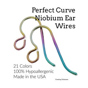May include: Two iridescent niobium ear wires with a curved design. The text reads: Perfect Curve Niobium Ear Wires, 21 Colors, 100% Hypoallergenic, Made in the USA, Creating Unkamen. The metal features a gradient of purple, blue, and gold tones.