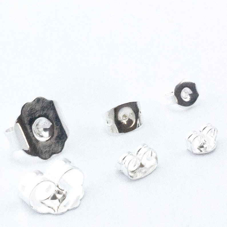 May include: Four silver earring backs, two are butterfly backs and two are push backs.
