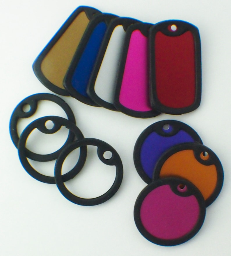 May include: Assortment of blank, round and rectangular dog tags in various colors, including red, purple, orange, pink, blue, white, and brown. The tags are made of a durable material and have a black border.