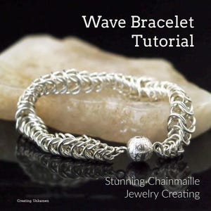 May include: A silver chainmail bracelet with a wave pattern. The bracelet has a silver bead clasp. The bracelet is on a white rock and a black reflective surface. The text "Wave Bracelet Tutorial" and "Stunning Chainmaille Jewellery Creating" is visible in the image.