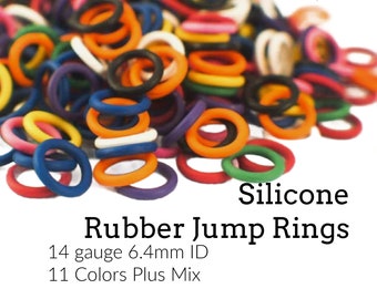 May include: A pile of colorful silicone rubber jump rings in various colors, including red, orange, yellow, green, blue, purple, black, and white. The text reads "Silicone Rubber Jump Rings, 14 gauge 6.4mm ID, 11 Colors Plus Mix."