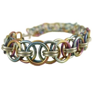 May include: A multi-colored metal bracelet with a chain link design. The bracelet is made of silver, gold, blue, and pink metal.