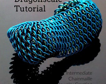 May include: A cylindrical chainmaille piece featuring interlocking blue and green metal rings in a dragonscale pattern. The text reads: "Dragonscale Tutorial", "Intermediate Chainmaille Jewelry Creating", and "Creating Unkamen".