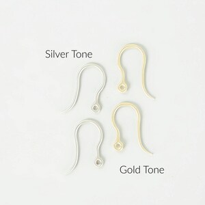 Puede incluir: Dos ganchos para pendientes en tono plateado y dos ganchos en tono dorado dispuestos verticalmente. El texto Silver Tone se sit&uacute;a sobre los ganchos plateados, y el texto Gold Tone se sit&uacute;a bajo los ganchos dorados a la derecha.