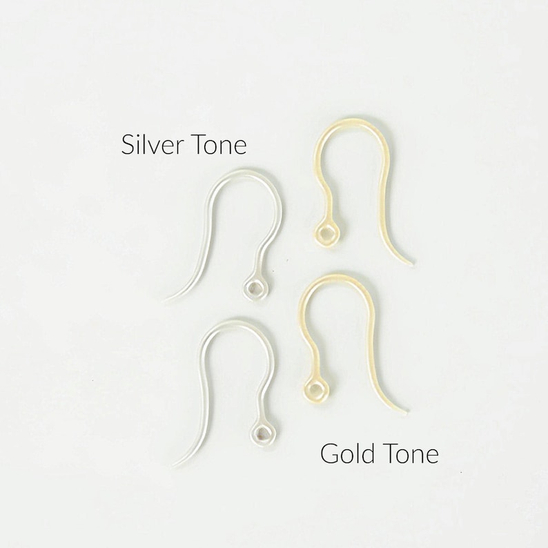 Puede incluir: Dos ganchos para pendientes en tono plateado y dos ganchos en tono dorado dispuestos verticalmente. El texto Silver Tone se sit&uacute;a sobre los ganchos plateados, y el texto Gold Tone se sit&uacute;a bajo los ganchos dorados a la derecha.