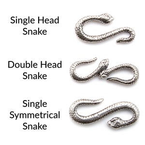May include: Three silver snake clasps, each with a different design. The top clasp is a single-headed snake, the middle clasp is a double-headed snake, and the bottom clasp is a single-headed snake with a symmetrical design.