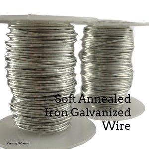 Puede incluir: Dos carretes de alambre de hierro galvanizado suave recocido. El alambre es de color plateado y está enrollado alrededor de los carretes.