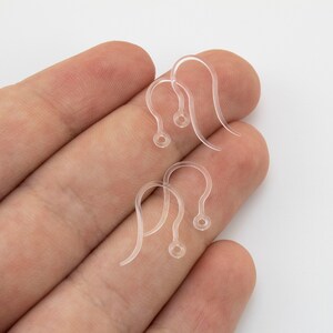 Puede incluir: Cuatro ganchos para pendientes de pl&aacute;stico transparente con un dise&ntilde;o curvo y un peque&ntilde;o bucle circular en la parte inferior para sujetar componentes de joyer&iacute;a. Estos fornituras ligeras son transparentes y tienen una forma suave.