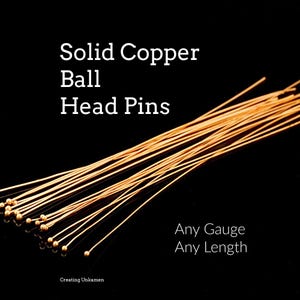 Peut inclure: Gros plan sur des épingles à tête sphérique en cuivre massif, sur fond noir. Les épingles sont dorées, avec de petites têtes rondes. Le texte indique "Solid Copper Ball Head Pins" et "Any Gauge Any Length".