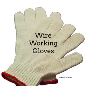 Puede incluir: Un par de guantes de trabajo de alambre de algodón blanco con ribete rojo. Los guantes están diseñados para proteger las manos de cortes y abrasiones al trabajar con alambre.