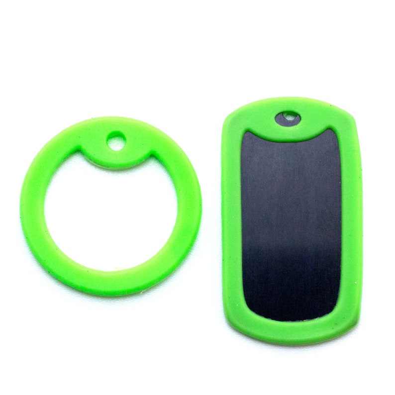 May include: Two green dog tags, one with a round ring and the other with a rectangular blank space for engraving.