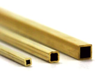 May include: Three metallic rods with a square cross-section arranged in a diagonal line. Each rod features a smooth, gold-toned finish and a hollow center, displaying a consistent square profile from the smallest to the largest size.