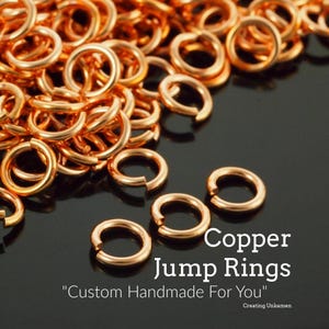 May include: Close-up of copper jump rings, perfect for jewelry making. The rings are a warm, shiny copper color and are scattered across a dark surface. Text on the image reads "Copper Jump Rings" and "Custom Handmade For You".