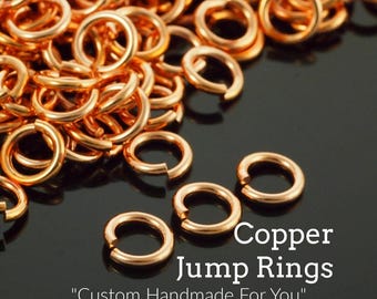 May include: Close-up of copper jump rings, perfect for jewelry making. The rings are a warm, shiny copper color and are scattered across a dark surface. Text on the image reads "Copper Jump Rings" and "Custom Handmade For You".
