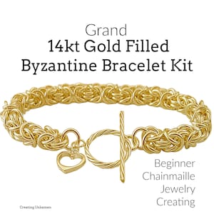 Pode incluir: Um kit de pulseira bizantina dourada com fecho de alternância e um berloque de coração. A pulseira é feita de corrente de malha preenchida com ouro 14k. O texto na imagem diz "Grand 14kt Gold Filled Byzantine Bracelet Kit" e "Beginner Chainmaille Jewelry Creating."