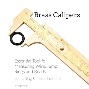 May include: A brass caliper with inch and meter measurements, holding a black jump ring. Text reads "Brass Calipers" and "Essential Tool for Measuring Wire, Jump Rings and Beads. Jump Ring Sampler Included."
