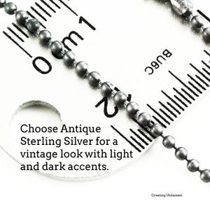 May include: A close-up of a silver chain measured against a ruler. The chain is made of small, round beads. The ruler shows measurements in centimeters. The text "Choose Antique Sterling Silver for a vintage look with light and dark accents." is visible on the ruler. The text "Creating Unkamen" is also visible on the ruler.
