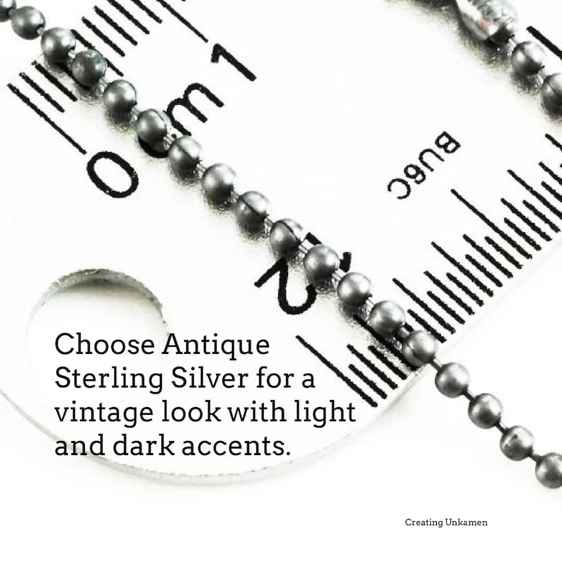 May include: A close-up of a silver chain measured against a ruler. The chain is made of small, round beads. The ruler shows measurements in centimeters. The text "Choose Antique Sterling Silver for a vintage look with light and dark accents." is visible on the ruler. The text "Creating Unkamen" is also visible on the ruler.
