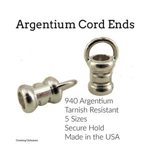 May include: Argentium cord ends in a silver finish. The image shows two cord ends, one with a loop and the other with a pin. Text on the image reads "Argentium Cord Ends", "940 Argentium Tarnish Resistant", and "Made in the USA".