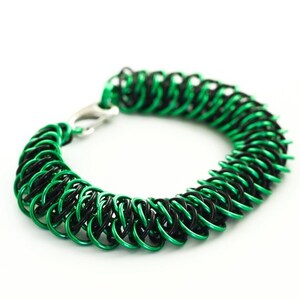 May include: A green and black chainmail bracelet with a silver clasp.