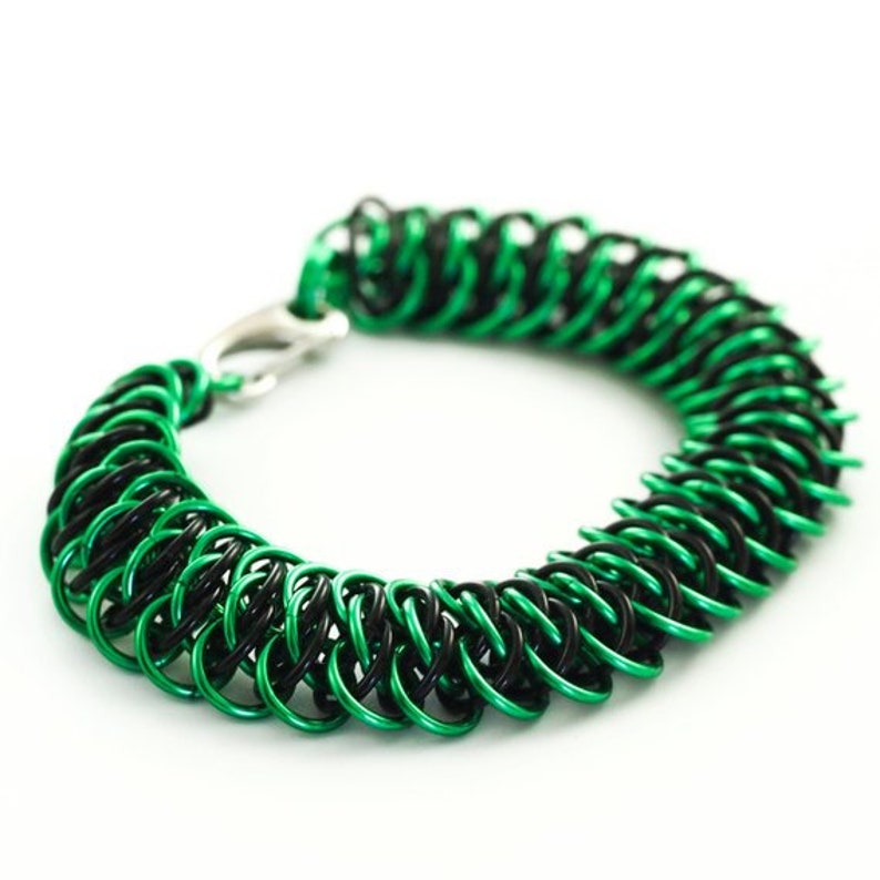 May include: A green and black chainmail bracelet with a silver clasp.