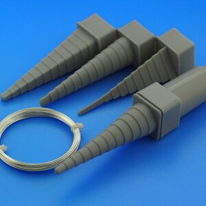 May include: Four grey plastic tapered tools for shaping wire, with a coil of silver wire in the centre.