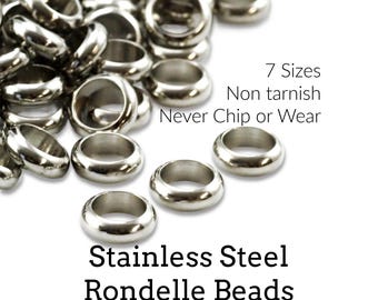 Może przedstawiać: Kolekcja polerowanych koralików typu rondelle ze stali nierdzewnej w kolorze srebrnym. Tekst na obrazku brzmi: 7 Sizes, Non tarnish, Never Chip or Wear, Stainless Steel Rondelle Beads, Creating Unkamen. Koraliki te mają gładki, zaokrąglony kształt.